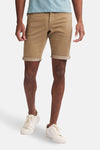 Korte beige short van Petrol Industries met omgeslagen zomen, gedragen met witte schoenen.
