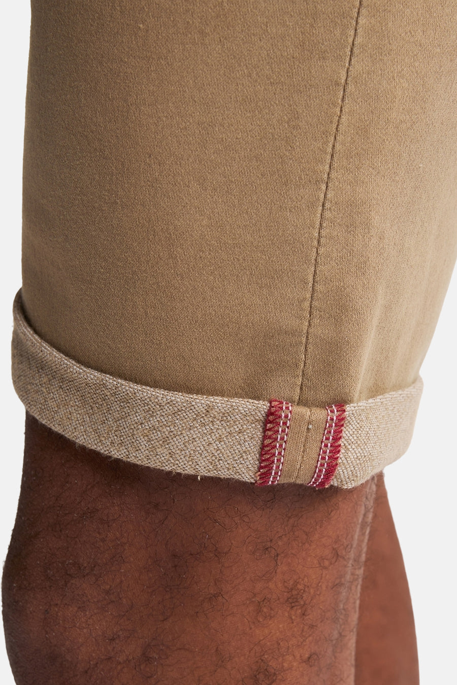 Korte beige short van Petrol Industries met een omgeslagen zoom die een rode bies onthult.