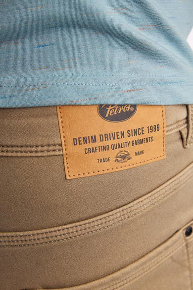 Korte beige short van Petrol Industries, met een leren label aan de achterkant en decoratieve stiksels.
