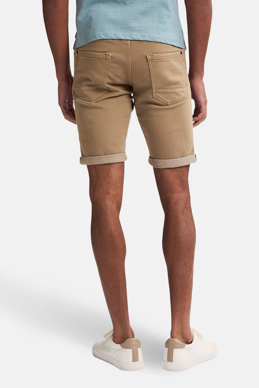 Short beige de Petrol Industries avec ourlets retournés, porté avec des chaussures blanches.