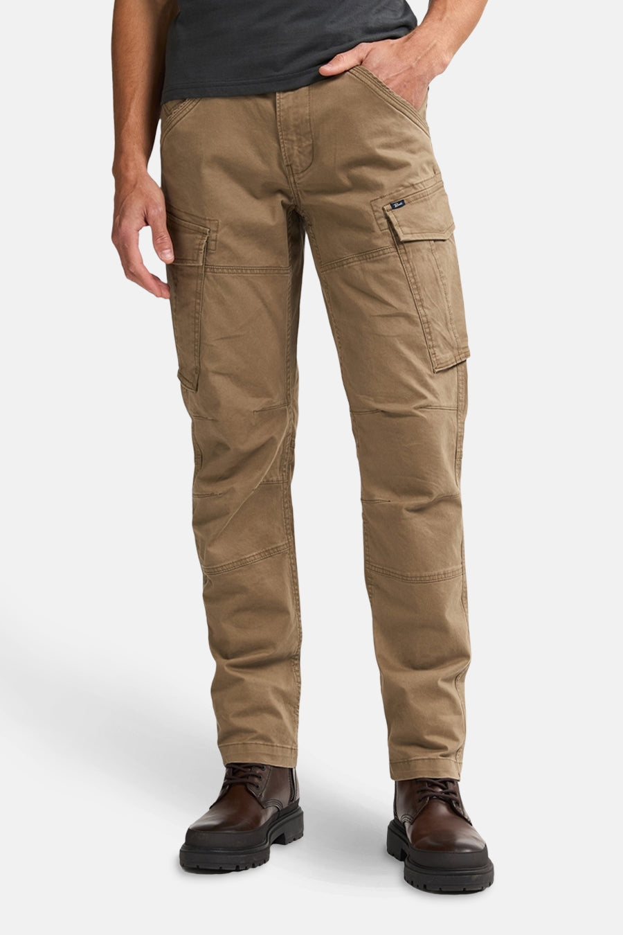 Pantalon cargo écru de Petrol Industries, avec poches latérales et détails de couture sur les genoux, porté avec des bottines marron.