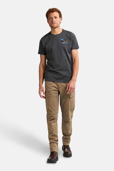 Pantalon cargo écru de Petrol Industries, avec poches cargo visibles et des bottines en cuir marron.