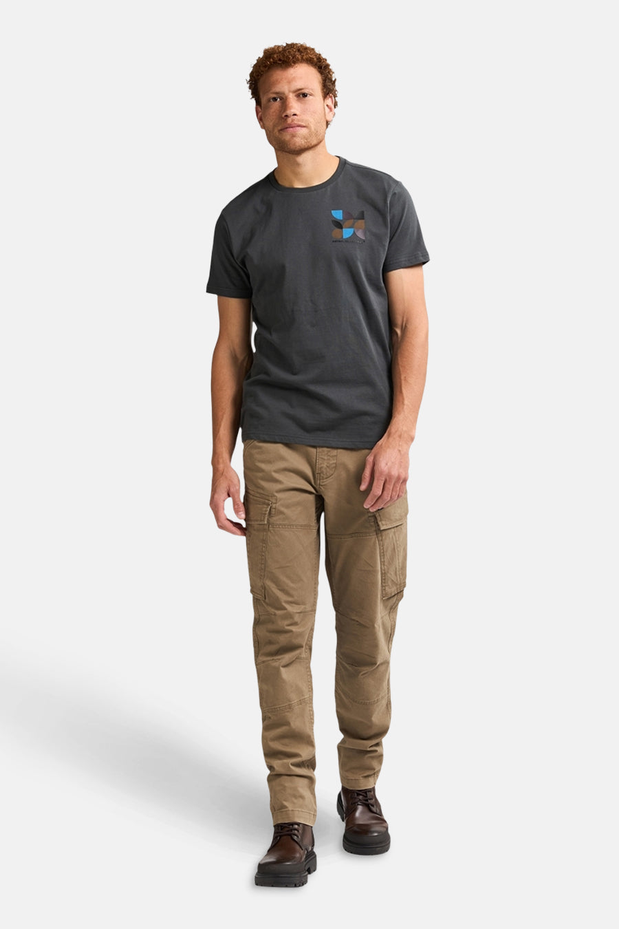 Pantalon cargo écru de Petrol Industries, avec poches cargo visibles et des bottines en cuir marron.