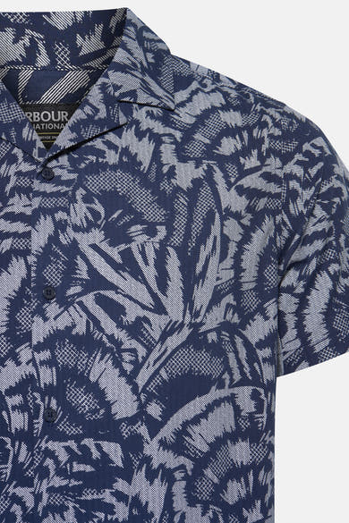 Chemise à manches courtes bleue à motif palmiers par Barbour, avec boutons foncés et col cubain.