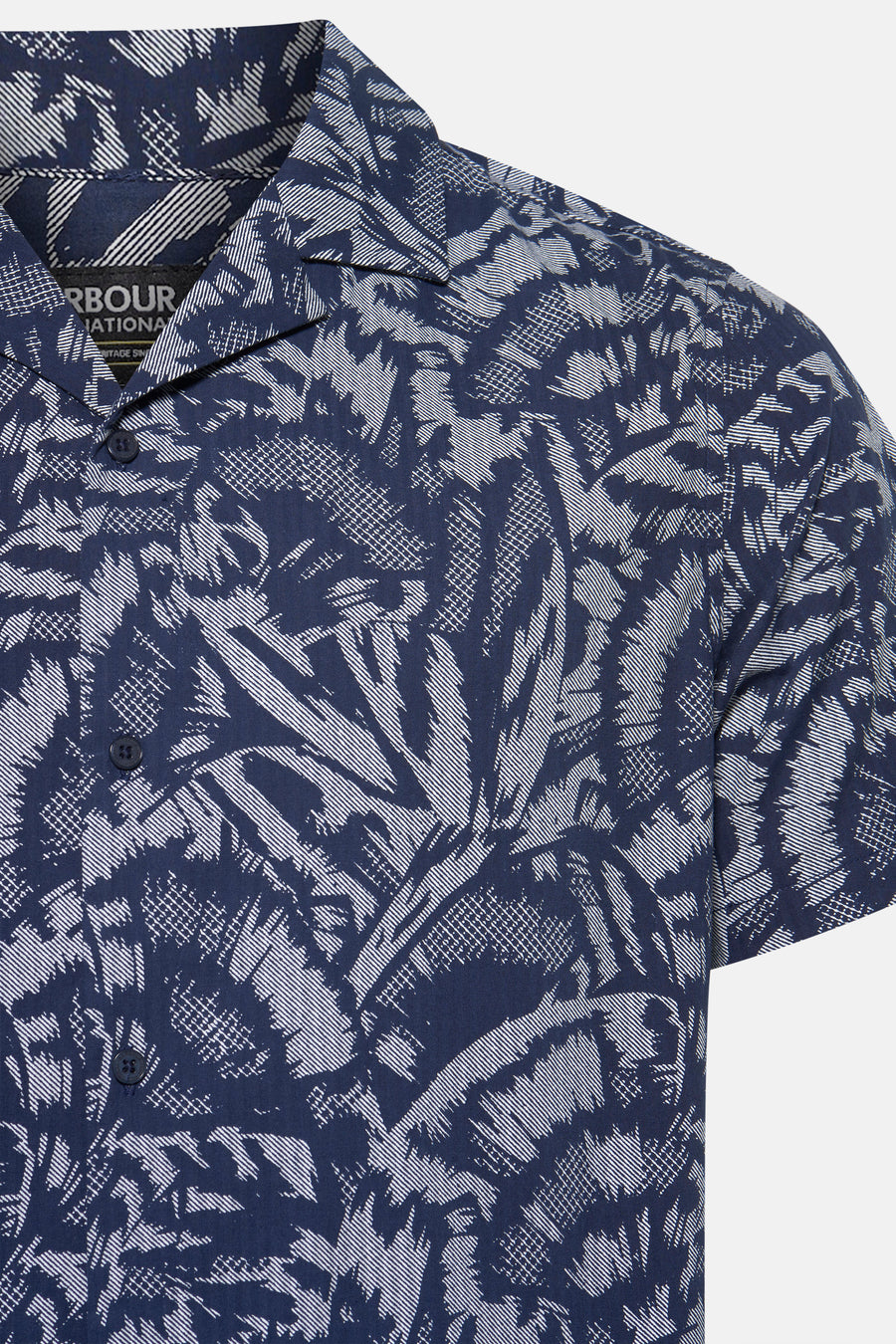 Chemise à manches courtes bleue à motif palmiers par Barbour, avec boutons foncés et col cubain.