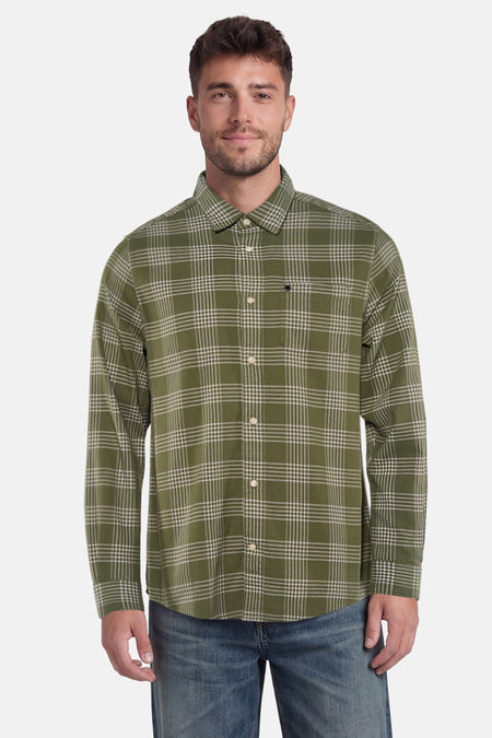 Chemise à manches longues verte de BARBOUR à carreaux blancs, avec une poche poitrine, portée par un homme avec un jean.
