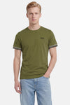 T-shirt à manches courtes vert de Barbour avec logo Barbour International et rayures noires et blanches sur les manches.