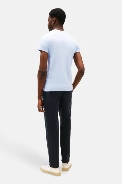 Blauw T-shirt met korte mouwen van TOMMY HILFIGER, gedragen met een donkere broek en lichte sneakers, achtergezicht.