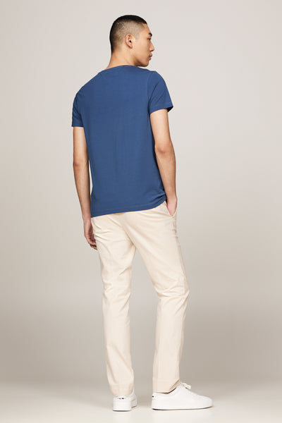 Blauw T-shirt met korte mouwen van TOMMY HILFIGER, gedragen met een beige broek en witte sneakers, achtergezicht.