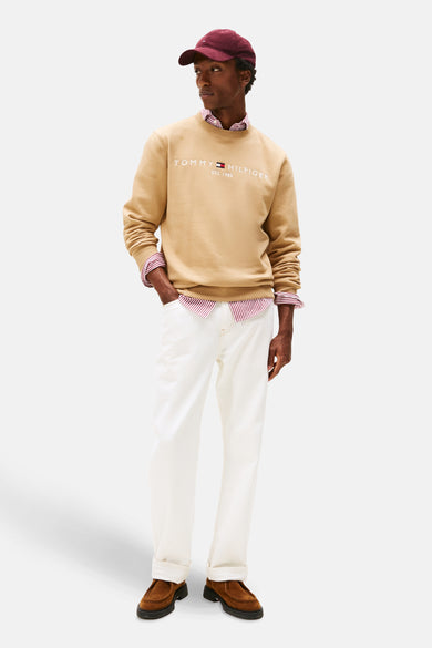 Beige sweatshirt van TOMMY HILFIGER met een ronde hals, gedragen met een gestreept overhemd en een witte broek.