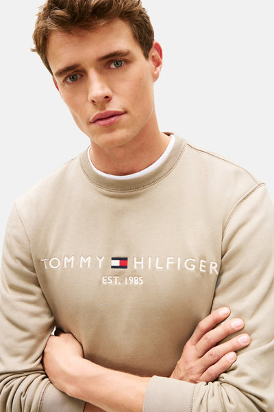 Kaki sweatshirt van Tommy Hilfiger met geborduurd logo aan de voorkant, gedragen met een T-shirt met ronde hals.