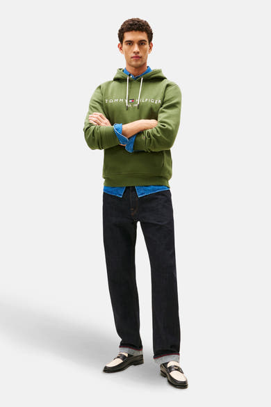 Sweat vert à capuche de TOMMY HILFIGER, porté sur une chemise en denim, avec un jean foncé et des mocassins.