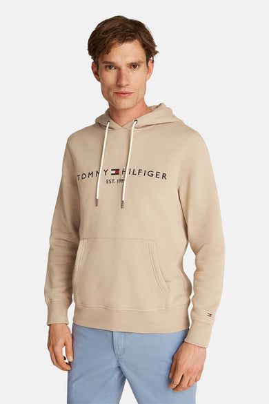 Sweat-shirt beige à capuche de Tommy Hilfiger, avec logo imprimé sur le devant et cordon blanc.