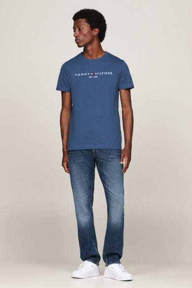 T-shirt à manches courtes bleu de Tommy Hilfiger, porté avec un jean et des baskets blanches.