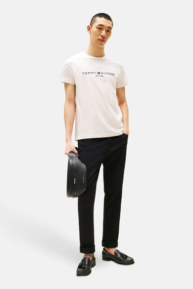 Beige T-shirt met korte mouwen van Tommy Hilfiger gedragen met een zwarte broek en leren loafers.