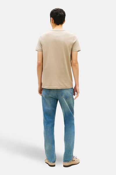 T-shirt à manches courtes beige de TOMMY HILFIGER, porté avec un jean bleu et des chaussures bateau, vue de dos.