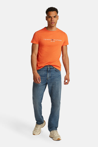 Oranje T-shirt met korte mouwen van TOMMY HILFIGER, gedragen met een blauwe jeans en beige sneakers