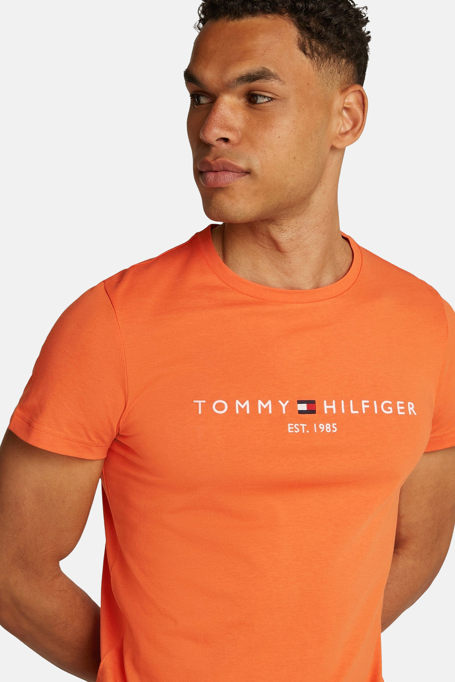 T-shirt orange à manches courtes de Tommy Hilfiger avec le logo de la marque imprimé.