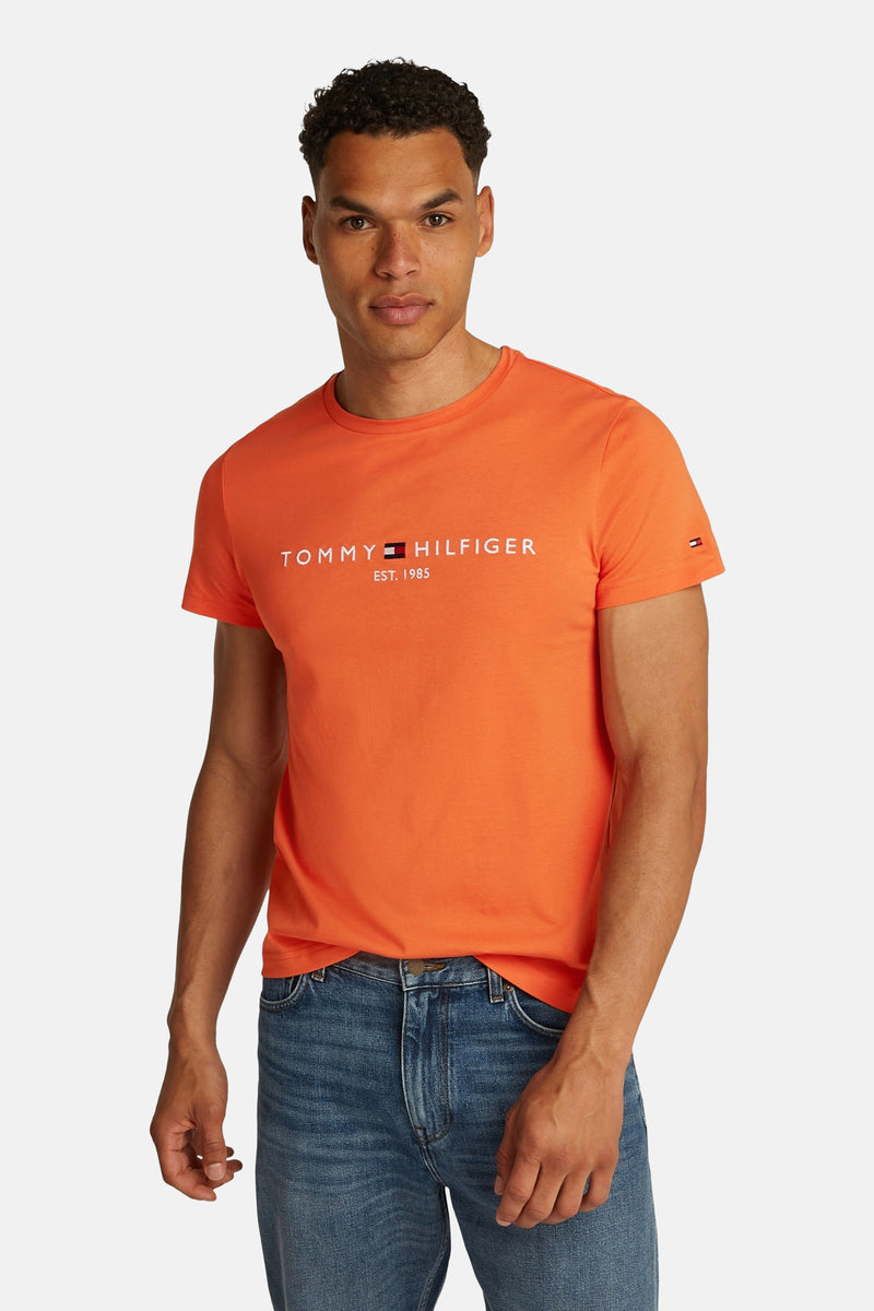 Oranje T-shirt met korte mouwen van TOMMY HILFIGER, gedragen met een blauwe spijkerbroek.