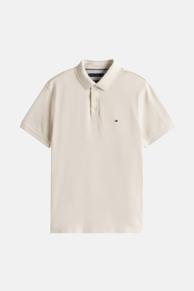 Polo beige à manches courtes de TOMMY HILFIGER, avec logo brodé sur la poitrine et patte de boutonnage.