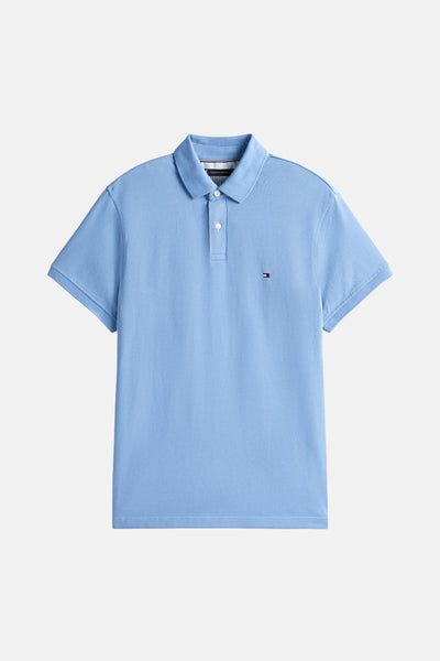 Polo bleu à manches courtes de TOMMY HILFIGER, avec logo sur la poitrine et patte de boutonnage blanche.
