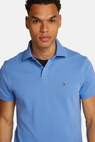 Polo bleu en piqué de coton par Tommy Hilfiger, avec logo brodé et coupe classique.
