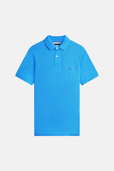 Polo bleu à manches courtes de Tommy Hilfiger avec logo distinctif sur la poitrine, sur fond blanc.