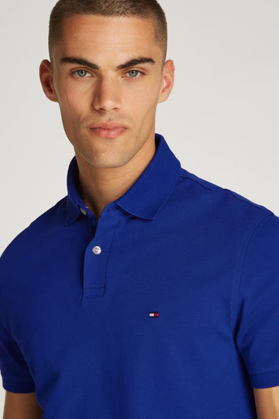 Polo bleu à manches courtes de TOMMY HILFIGER, avec le logo drapeau distinctif sur la poitrine.