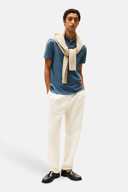 Polo à manches courtes bleu de TOMMY HILFIGER avec un pull en maille torsadée sur les épaules.