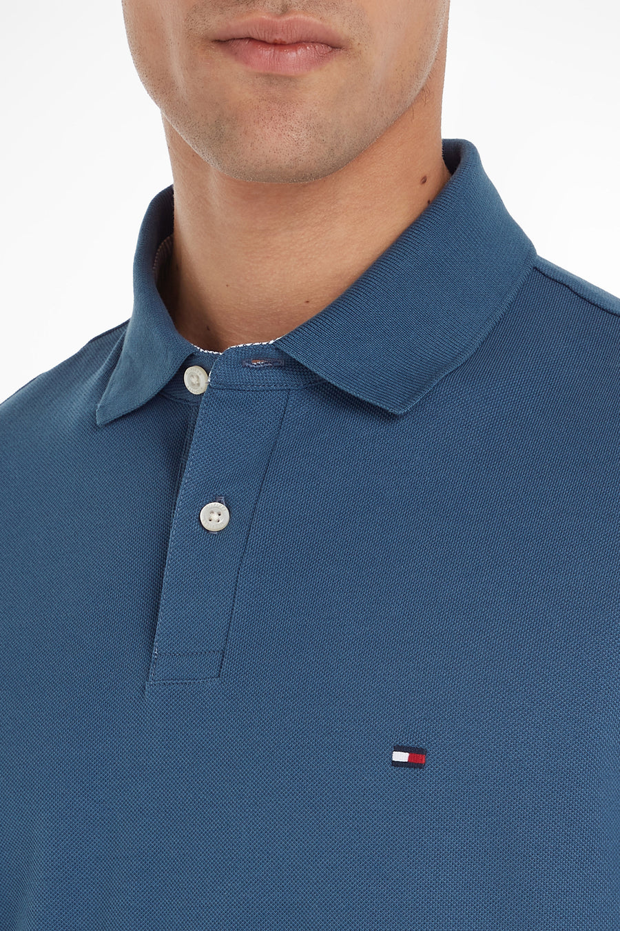 Polo blauw met korte mouwen van Tommy Hilfiger met witte knopen en logo aan de zijkant.