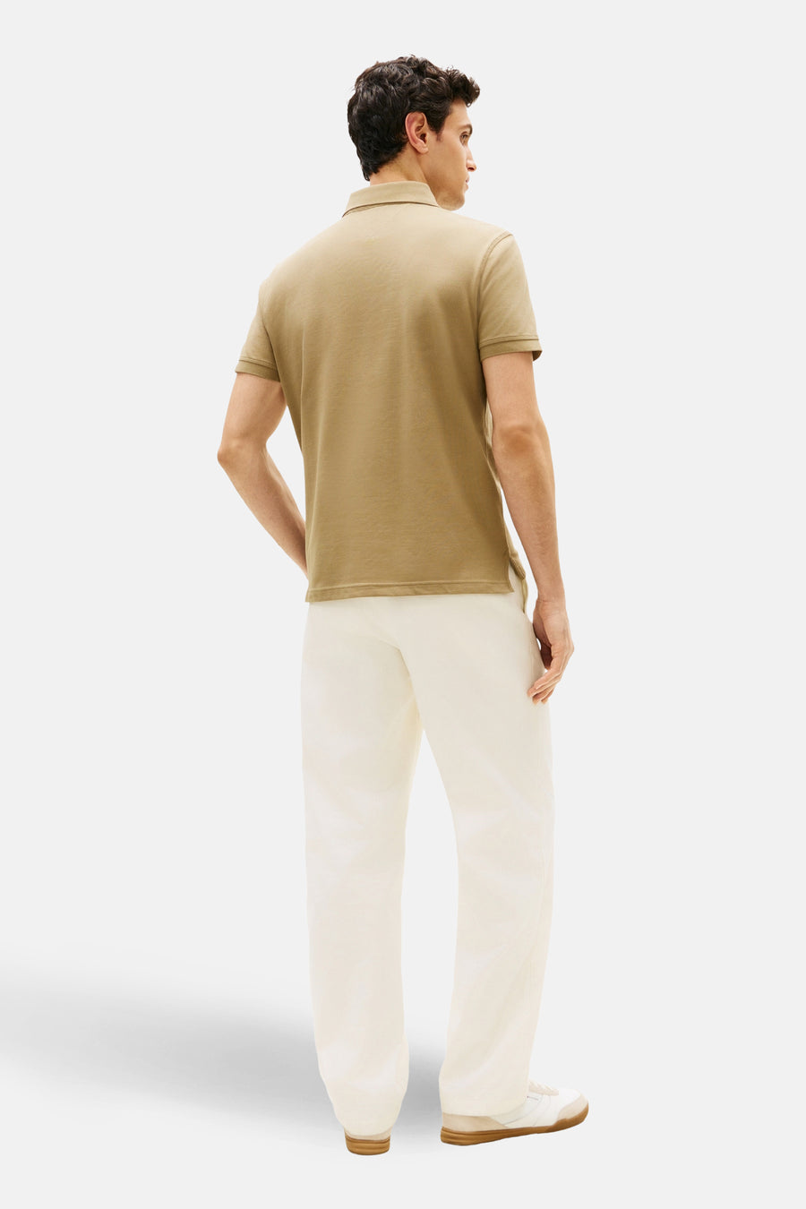 Polo à manches courtes kaki de TOMMY HILFIGER, porté avec un pantalon écru et des baskets blanches, vue arrière.