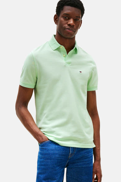 Polo vert à manches courtes de Tommy Hilfiger, porté avec un jean bleu.