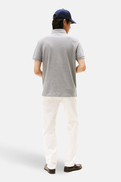 Polo gris de TOMMY HILFIGER, porté avec un pantalon blanc et des mocassins en cuir marron, vue arrière.