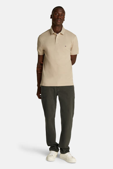 Beige korte mouw polo van TOMMY HILFIGER, gedragen met een oliegroene broek en witte sneakers.