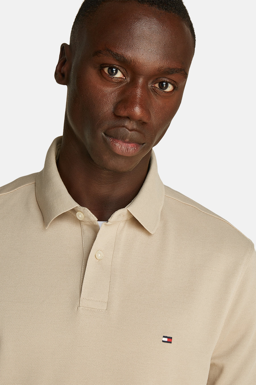 Polo beige met TOMMY HILFIGER,GERgergerger tricolorelogocolcolge door een man.