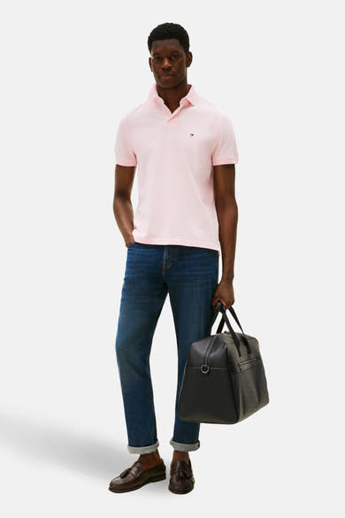 Polo à manches courtes rose de TOMMY HILFIGER, porté avec un jean bleu et des mocassins en cuir marron.