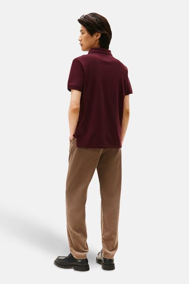 Polo rood met korte mouwen van TOMMY HILFIGER, gedragen met een beige velourskousen en zwarte schoenen.