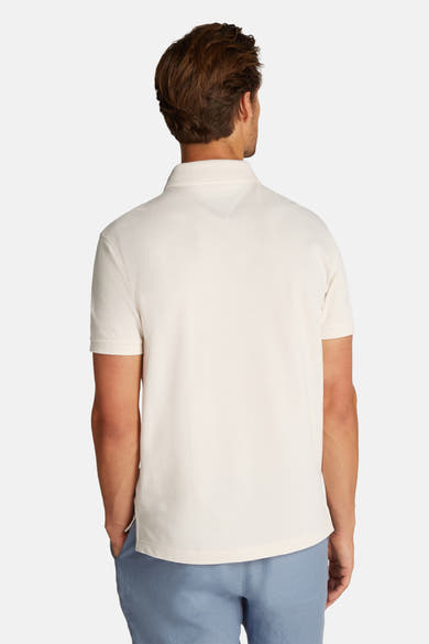 Korte mouw polo van TOMMY HILFIGER, geel, gemaakt van geburde katoen, gedragen met een lichte blauwe broek, rugzijde.