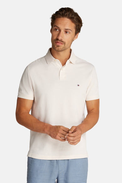 Polo à manches courtes écru de Tommy Hilfiger, porté avec un pantalon bleu clair.