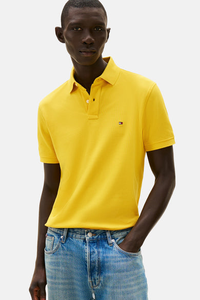Polo jaune à manches courtes de TOMMY HILFIGER porté avec un jean délavé.