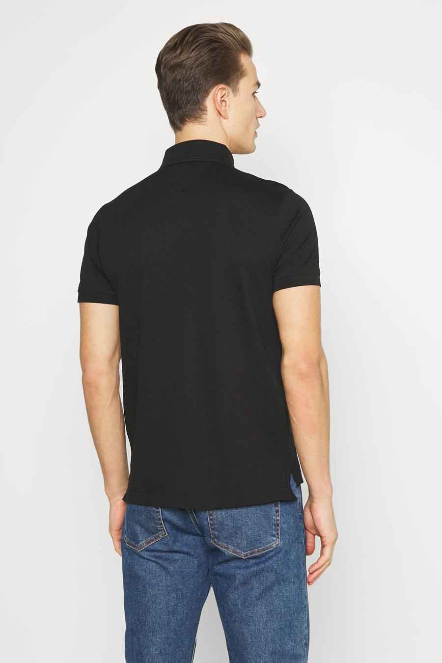 Zwart Tommy Hilfiger poloshirt, achterkant, gedragen met een blauwe spijkerbroek.