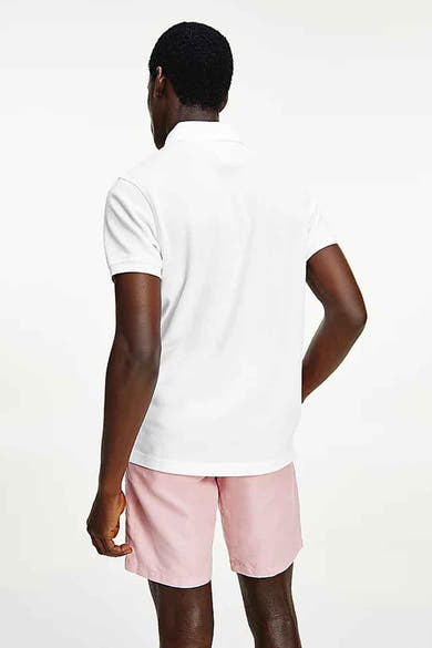 Wit Tommy Hilfiger poloshirt, gedragen met een roze korte broek, achterzijde.
