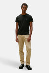 T-shirt noir à manches courtes de TOMMY HILFIGER, porté avec un pantalon beige et des chaussures noires.