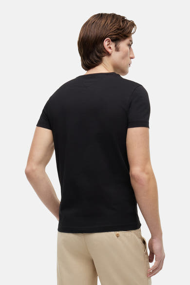 T-shirt à manches courtes noir de Tommy Hilfiger, porté avec un pantalon chino beige, vue de dos.
