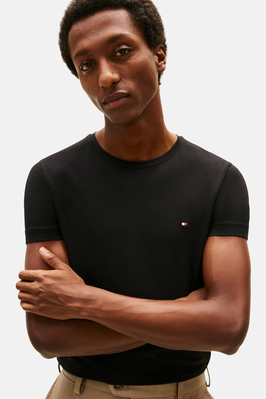 T-shirt à manches courtes noir de TOMMY HILFIGER, porté avec un pantalon beige.