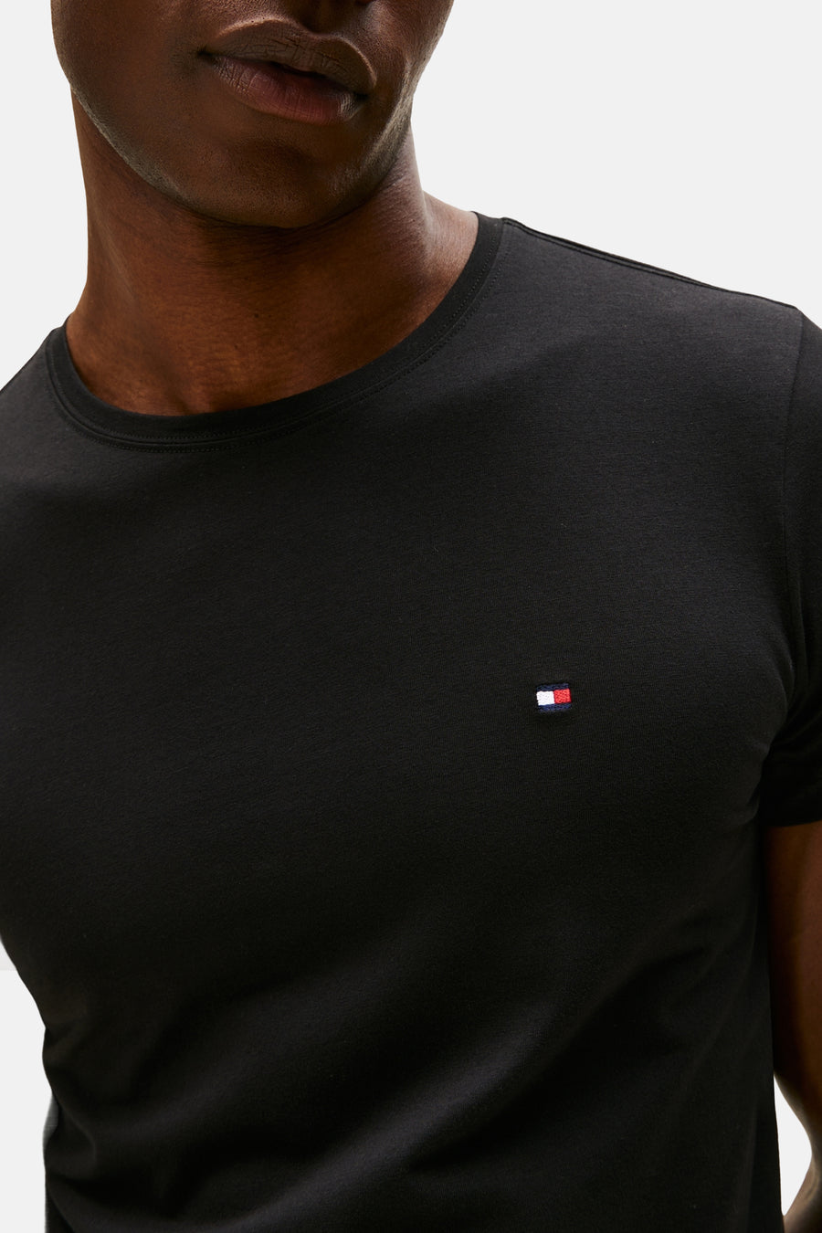 T-shirt à manches courtes noir de TOMMY HILFIGER, avec un petit logo tricolore sur la poitrine.
