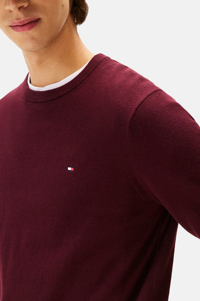 Pull à col rond bordeaux de Tommy Hilfiger, avec un petit logo brodé sur la poitrine et un col rond blanc.