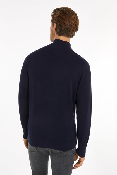 Pull à col roulé bleu de TOMMY HILFIGER, vue de dos, porté avec un jean gris.
