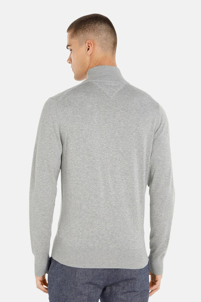 Grijze coltrui van Tommy Hilfiger, stikseldetail bij de kraag, aansluitende pasvorm, gedragen met een marineblauwe broek.