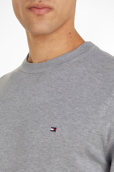 Pull col rond gris de Tommy Hilfiger, avec le logo brodé sur la poitrine.
